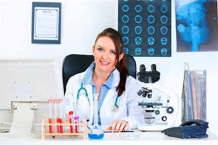 simsearch:400-07099889,k - Smiling medical doctor woman sitting at table in office Stock Photo - Budget Royalty-Free & Subscription, Code: 400-04874957