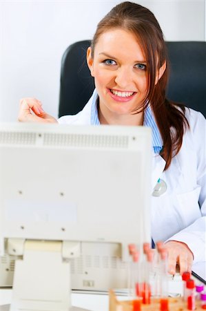 simsearch:400-04925813,k - Smiling medical doctor woman sitting at office table and working on computer Stock Photo - Budget Royalty-Free & Subscription, Code: 400-04874958