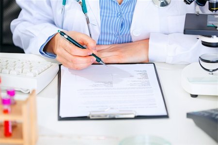 simsearch:400-07519214,k - Medical doctor woman sitting at office table and working with document. Close-up Stock Photo - Budget Royalty-Free & Subscription, Code: 400-04874961