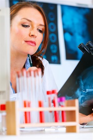 simsearch:400-04925813,k - Pensive medical doctor woman sitting at office table and looking patients roentgen Stock Photo - Budget Royalty-Free & Subscription, Code: 400-04874962