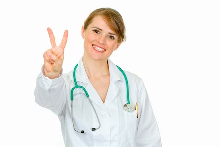 simsearch:400-04351236,k - Smiling medical doctor woman showing victory gesture isolated on white Photographie de stock - Aubaine LD & Abonnement, Code: 400-04875491