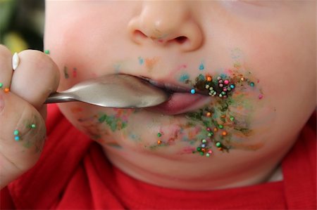 Close up of baby boy mouth covered with cake decorations Foto de stock - Super Valor sin royalties y Suscripción, Código: 400-04876545