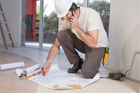 Construction worker working on blueprint and talking on cellphone Photographie de stock - Aubaine LD & Abonnement, Code: 400-04876998