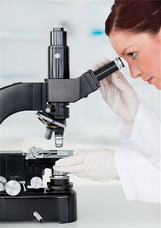 Beautiful red-haired scientist looking through a microscope in a lab Stock Photo - Budget Royalty-Free & Subscription, Code: 400-04878875