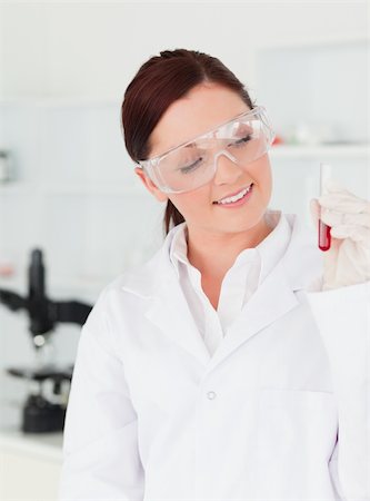 Pretty red-haired scientist looking at a test tube in a lab Stock Photo - Budget Royalty-Free & Subscription, Code: 400-04879287