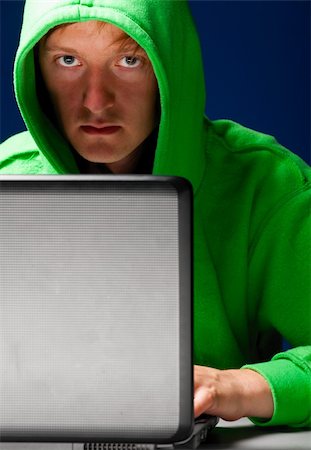 hacker. Young man with laptop is looking at camera Stock Photo - Budget Royalty-Free & Subscription, Code: 400-04879377