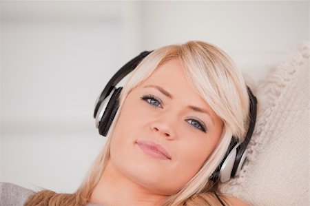 simsearch:400-04418454,k - Beautiful happy blond woman with headphones lying in a sofa in the living room Stockbilder - Microstock & Abonnement, Bildnummer: 400-04870929
