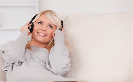 simsearch:400-04418454,k - Beautiful blond woman with headphones lying in a sofa in the living room Stockbilder - Microstock & Abonnement, Bildnummer: 400-04870921