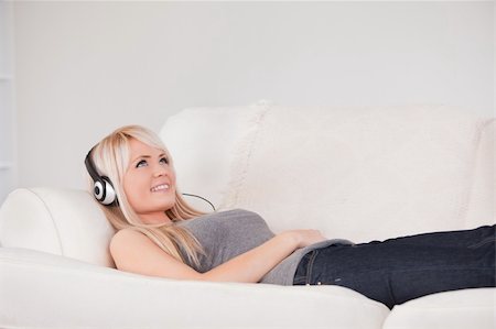 simsearch:400-04418454,k - Smiling young blond woman with headphones lying in a sofa in a studio Stockbilder - Microstock & Abonnement, Bildnummer: 400-04870937