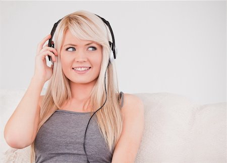 simsearch:400-04418452,k - Beautiful young blond woman with headphones sitting in a sofa in a studio Photographie de stock - Aubaine LD & Abonnement, Code: 400-04870930