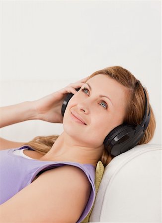 simsearch:400-04418454,k - Cute blond-haired woman listening to music lying on the sofa in the living-room Foto de stock - Royalty-Free Super Valor e Assinatura, Número: 400-04871204