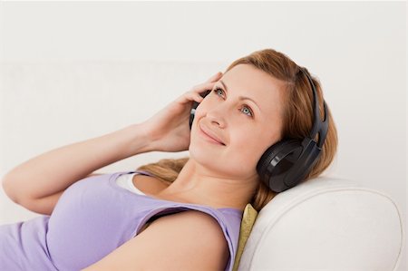simsearch:400-04418454,k - Smiling blond-haired woman listening to music lying on the sofa in the living-room Foto de stock - Royalty-Free Super Valor e Assinatura, Número: 400-04871206