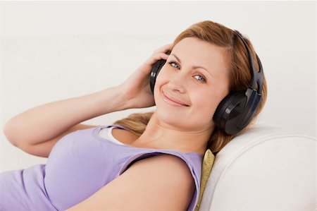 simsearch:400-04418452,k - Beautiful blond-haired woman listening to music lying on the sofa in the living-room Photographie de stock - Aubaine LD & Abonnement, Code: 400-04871201