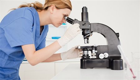 simsearch:400-05670345,k - Female scientist looking through a microscope in a lab Photographie de stock - Aubaine LD & Abonnement, Code: 400-04871330