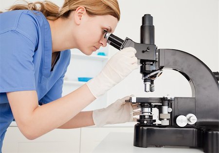 simsearch:400-04548222,k - Female scientist conducting an experiment looking through a microscope in a lab Stockbilder - Microstock & Abonnement, Bildnummer: 400-04871331