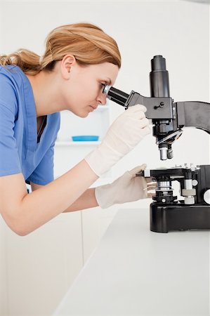 simsearch:400-05670345,k - Blond-haired scientist looking through a microscope in a lab Photographie de stock - Aubaine LD & Abonnement, Code: 400-04871332