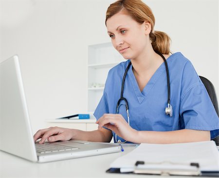 Cute female doctor working on her laptop in her surgery Stock Photo - Budget Royalty-Free & Subscription, Code: 400-04871357