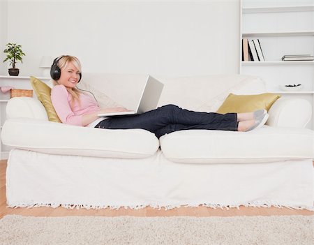 simsearch:400-04905827,k - Good looking woman listening to music on her headphones while lying on a sofa in the living room Stock Photo - Budget Royalty-Free & Subscription, Code: 400-04871517