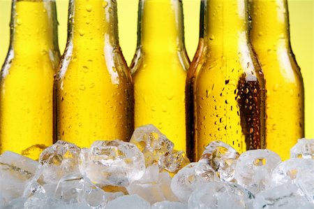 simsearch:400-05895285,k - Bottles of cold and fresh beer with ice over yellow background Fotografie stock - Microstock e Abbonamento, Codice: 400-04871882