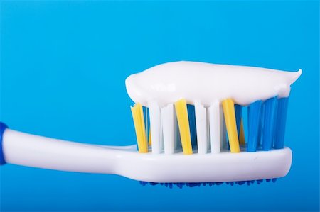 Closeup view of toothbrush with toothpaste over blue background Stock Photo - Budget Royalty-Free & Subscription, Code: 400-04872312