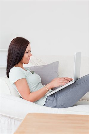 Beautiful woman typing on her laptop on her sofa Stock Photo - Budget Royalty-Free & Subscription, Code: 400-04884020