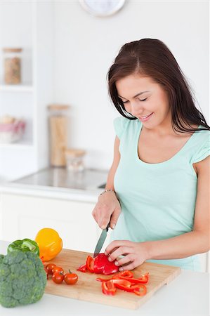 Cute brunette slicing a pepper in her kitchen Stock Photo - Budget Royalty-Free & Subscription, Code: 400-04884084