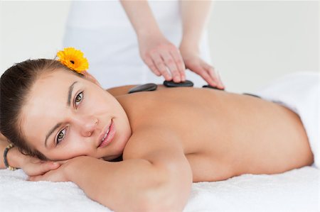 simsearch:400-04881818,k - Close up of a delighted woman having a hot stone massage while looking at the camera Foto de stock - Super Valor sin royalties y Suscripción, Código: 400-04884158