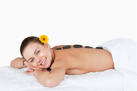 simsearch:400-04881818,k - Young woman having a LaStone therapy with a flower on her ear Fotografie stock - Microstock e Abbonamento, Codice: 400-04884150