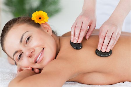 simsearch:400-04881816,k - Close up of a smiling woman enjoying a hot stone massage in a spa Stockbilder - Microstock & Abonnement, Bildnummer: 400-04884165