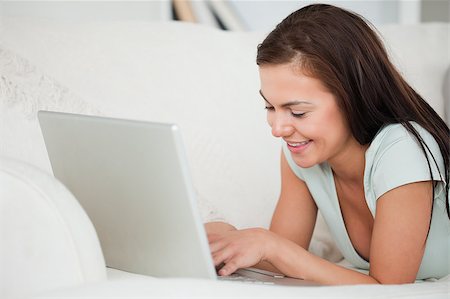 simsearch:400-04999709,k - Close up of a young brunette on a sofa using a laptop in her living room Photographie de stock - Aubaine LD & Abonnement, Code: 400-04884267