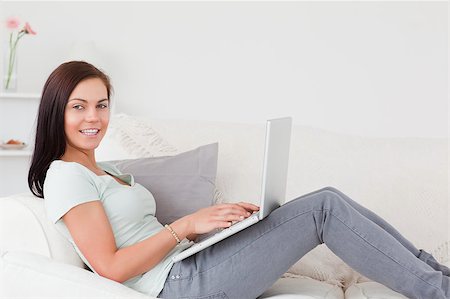 simsearch:400-04999709,k - Cute brunette typing on her laptop in her living room Photographie de stock - Aubaine LD & Abonnement, Code: 400-04884290