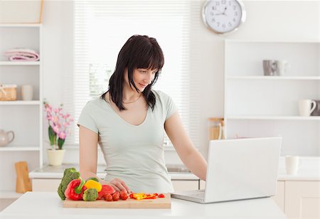 red pepper - Good looking brunette woman relaxing with her laptop while standing in the kitchen Foto de stock - Super Valor sin royalties y Suscripción, Código: 400-04884458