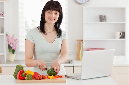 red pepper - Smiling brunette woman cooking while relaxing with her laptop in the kitchen Foto de stock - Super Valor sin royalties y Suscripción, Código: 400-04884467