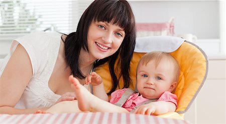 Beautiful brunette woman posing with her baby while sitting in the kitchen Stock Photo - Budget Royalty-Free & Subscription, Code: 400-04884535