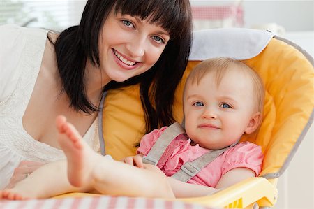 Good looking brunette woman posing with her baby while sitting in the kitchen Stock Photo - Budget Royalty-Free & Subscription, Code: 400-04884536