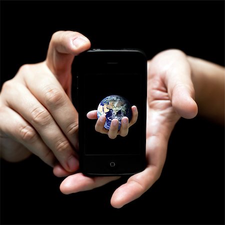 The world in your hands... smartphone (on black, very shallow depth of field) Stock Photo - Budget Royalty-Free & Subscription, Code: 400-04885598