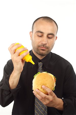 Portrait of young businessman eating hamburger over white Stock Photo - Budget Royalty-Free & Subscription, Code: 400-04886345