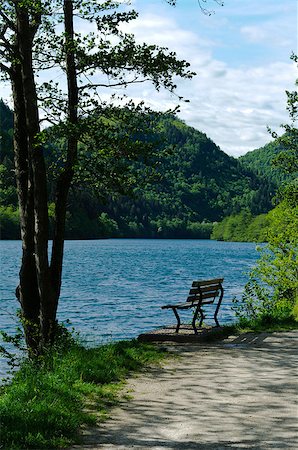 simsearch:400-05276155,k - A solitary wooden bench facing the calm waters of a beautiful Alpine lake Foto de stock - Royalty-Free Super Valor e Assinatura, Número: 400-04888189