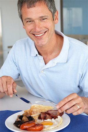 person eating bacon - Middle Aged Man Eating Unhealthy Fried Breakfast Stock Photo - Budget Royalty-Free & Subscription, Code: 400-04888255