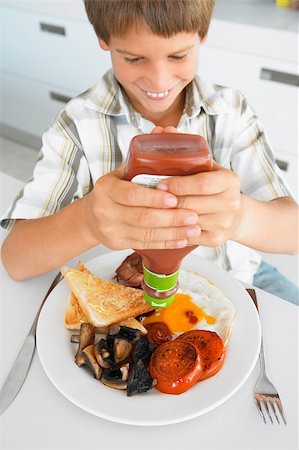 person eating bacon - Young Boy Eating Unhealthy Fried Breakfast Stock Photo - Budget Royalty-Free & Subscription, Code: 400-04888269