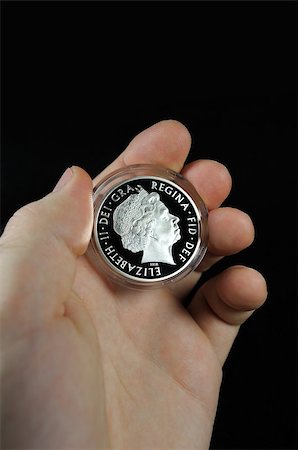 queen elizabeth - This photograph represents a man holding rare British one pound coin between thumb and forefinger, close-up Stock Photo - Budget Royalty-Free & Subscription, Code: 400-04880652