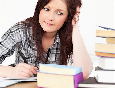 simsearch:400-04829236,k - Attractive red-haired girl studying for an examination at her desk Stock Photo - Budget Royalty-Free & Subscription, Code: 400-04880829
