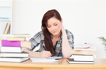 simsearch:400-04829236,k - Beautiful happy red-haired girl studying for an examination at her desk Stock Photo - Budget Royalty-Free & Subscription, Code: 400-04880846