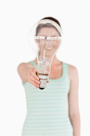 Pretty red-haired female holding a light bulb house while standing on a white background Stock Photo - Budget Royalty-Free & Subscription, Code: 400-04880938