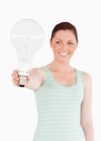 Pretty red-haired female holding a bulb while standing on a white background Stock Photo - Budget Royalty-Free & Subscription, Code: 400-04880980