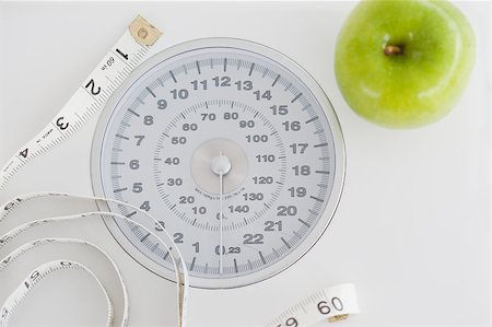 simsearch:400-03990146,k - Top view of a green apple along with a tape measure and a weigh-scale against a white background Foto de stock - Royalty-Free Super Valor e Assinatura, Número: 400-04881119