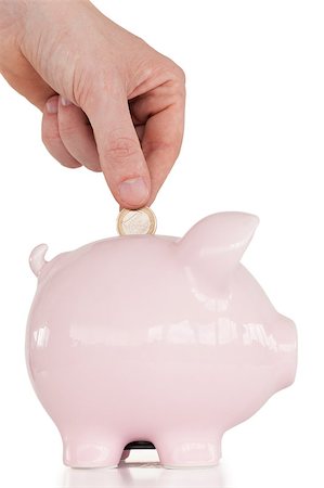 piggy bank hand - Hand inserting a coin in a pink piggy bank against a white background. Stock Photo - Budget Royalty-Free & Subscription, Code: 400-04881130