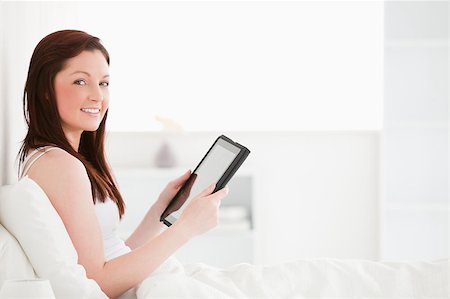 Beautiful red-haired female reading a book while sitting on her bed Stock Photo - Budget Royalty-Free & Subscription, Code: 400-04881488