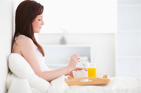 simsearch:400-04881612,k - Cute red-haired female drinking a glass of orange juice while sitting on her bed Stock Photo - Budget Royalty-Free & Subscription, Code: 400-04881493