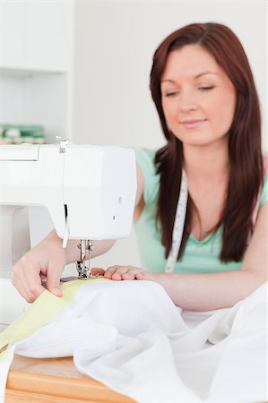 Beautiful red-haired female using a sewing machine in her living room Stock Photo - Budget Royalty-Free & Subscription, Code: 400-04881564